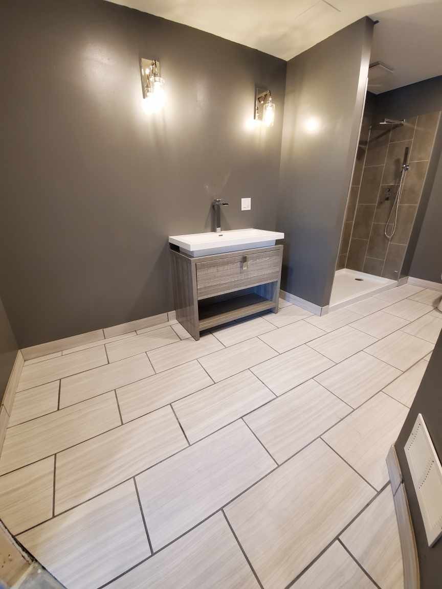Modern bathroom vanity with large-format tile flooring and custom cabinetry