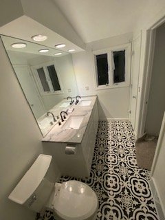 Modern bathroom renovation with custom vanity and patterned tile flooring