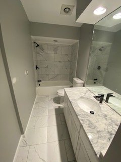 Custom marble bathroom with dual vanity and walk-in shower
