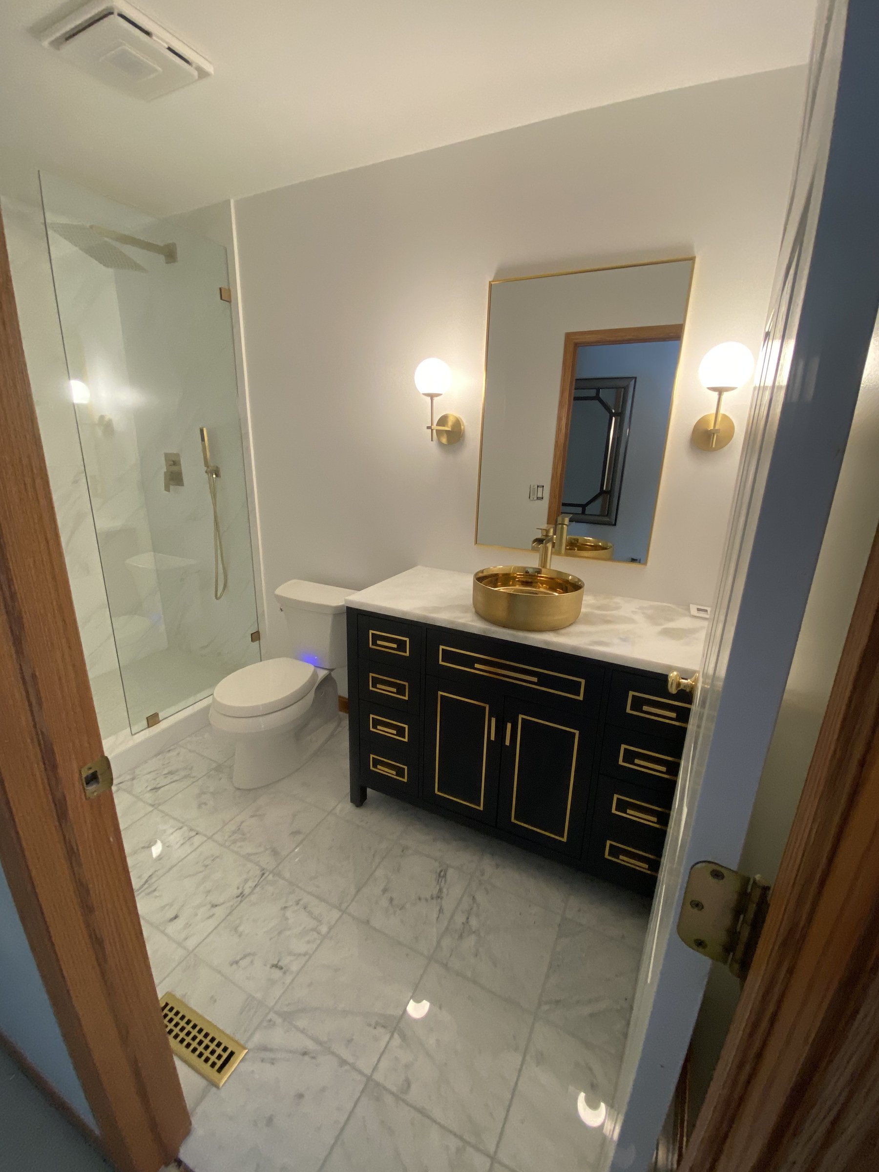 Custom vanity with marble countertop and brass hardware details