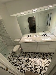 Modern bathroom vanity with dual sinks and geometric tile flooring