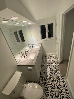Modern bathroom renovation with custom tile flooring and updated fixtures