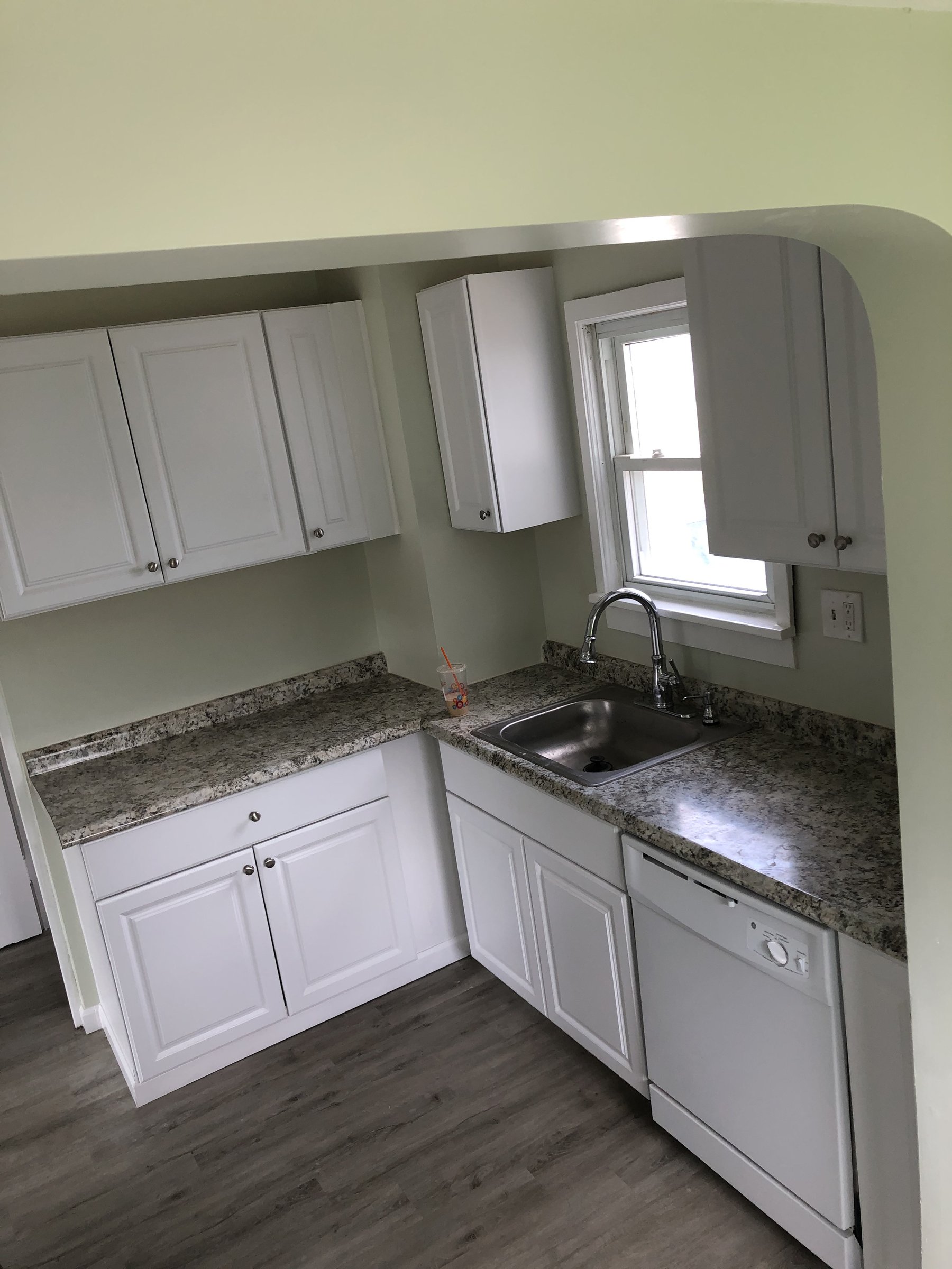 White cabinetry with granite counters and updated plumbing fixtures