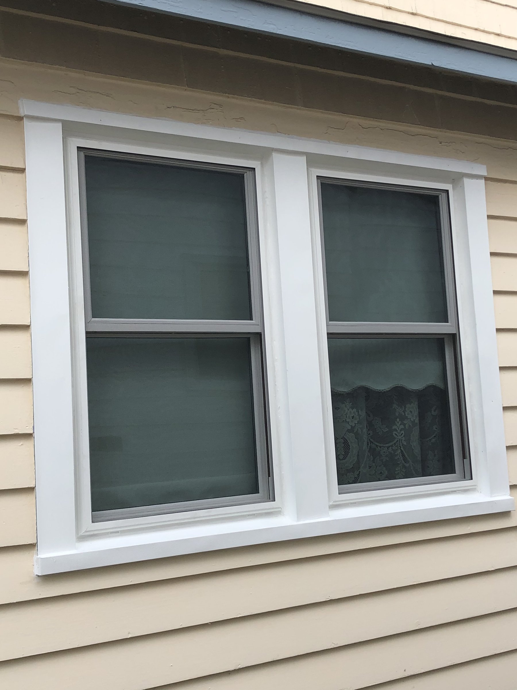 Professional window installation with clean white trim and casing