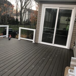 Modern composite deck with white vinyl railing and patio doors